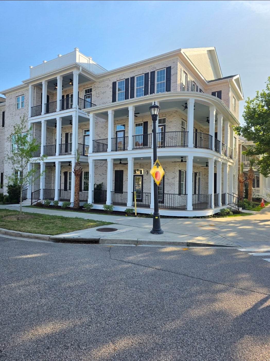 White multi story home with covered porches and columns